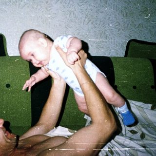 Man holding baby in bed.