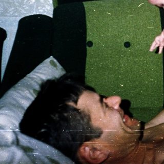 Man holding baby in bed.