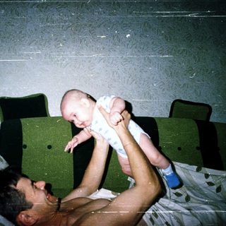 Man holding baby in bed.