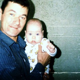 A man holding a baby indoors.