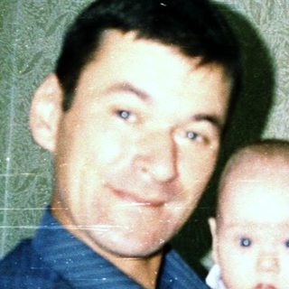A man holding a baby indoors.