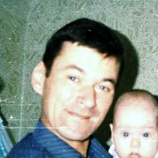 A man holding a baby indoors.