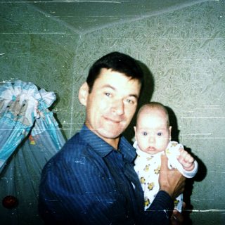 A man holding a baby indoors.