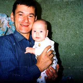 A man holding a baby in a celebratory setting.
