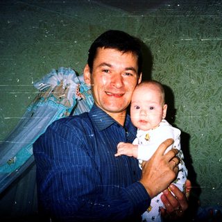 A man holding a baby in a celebratory setting.