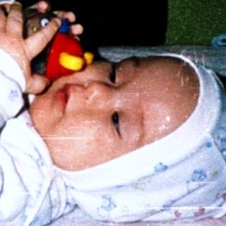 Baby sleeping peacefully with toy in hand.