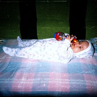 Baby sleeping peacefully with toy in hand.