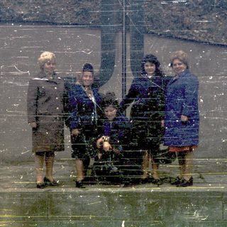 Five people posing outdoors in winter attire.