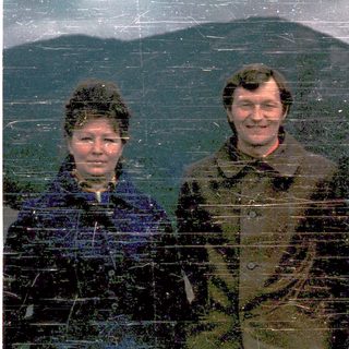 Three people posing outdoors in winter attire.