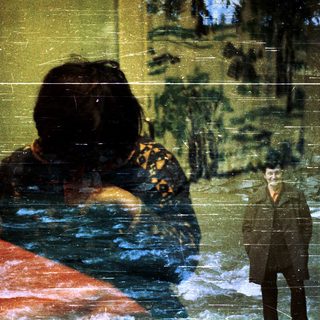 Reflection of man in rainy window.