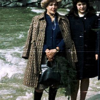 Three women posing near a rocky waterfall.