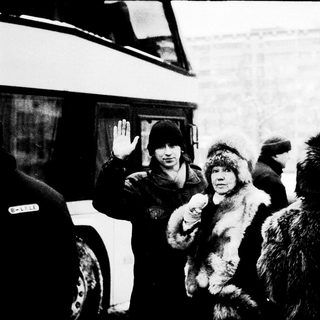 Cold winter scene with armed officers detaining a person.
