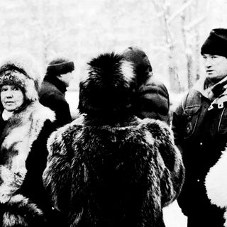 Cold winter scene with armed officers detaining a person.