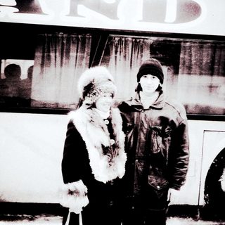 Two people posing outdoors in winter attire.