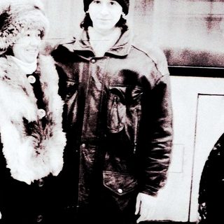 Two people posing outdoors in winter attire.