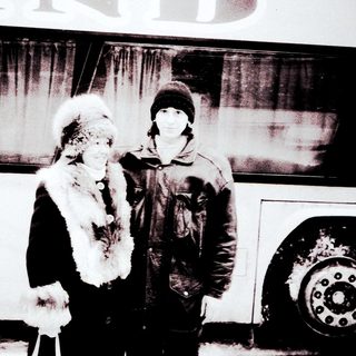 Two people posing outdoors in winter attire.