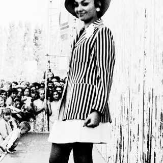 Elegant woman in striped dress posing outdoors.