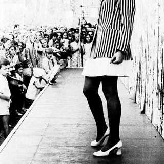 Elegant woman in striped dress posing outdoors.