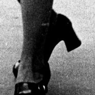 Young woman in 1960s-style dress walking confidently.