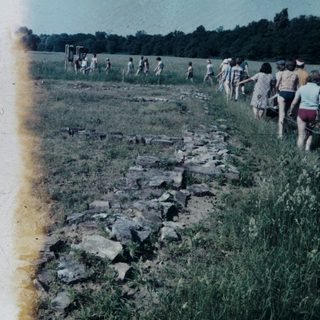 Group of people walking along exposed rock outcrop.