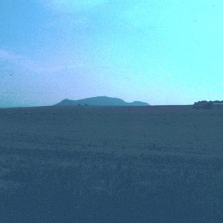 Dark ocean horizon with distant land silhouette.