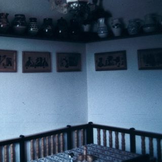 Vintage kitchen with ceramic jars, shelves, and rustic decor.