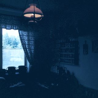 Cozy room with open curtains, dim lighting, and morning view.