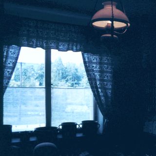 Cozy room with open curtains, dim lighting, and morning view.