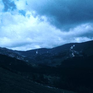 Majestic mountain range under cloudy sky.