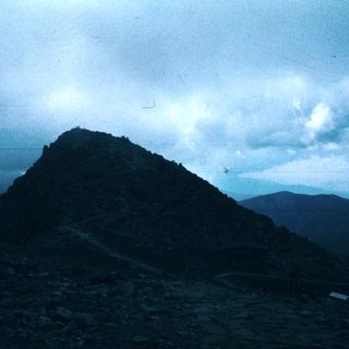 Misty mountain peak with rocky terrain.