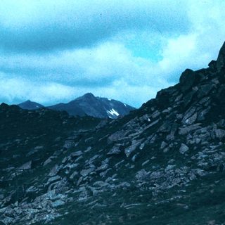 Majestic mountain range under cloudy sky.