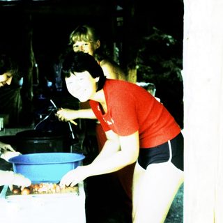 Group preparing food outdoors in rustic setting.