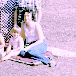 Family group photo outdoors in summer clothing.