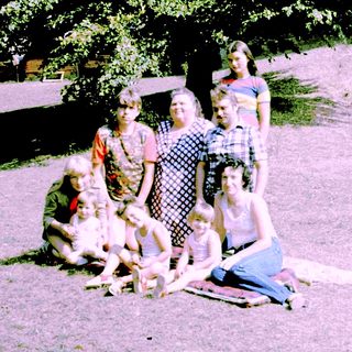 Family group photo outdoors in summer clothing.