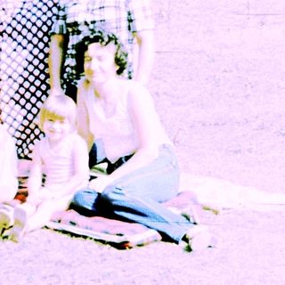 Family group posing outdoors in vintage clothing.