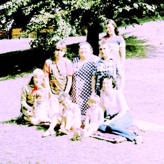 Family group posing outdoors in vintage clothing.