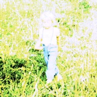 A person walking through tall grassy field.