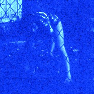 Blurred nighttime scene of two figures near house.