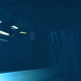 Empty, dimly lit room with desks.