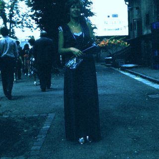 Woman holding lit torch in outdoor ceremony.