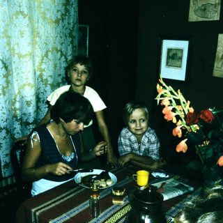 Family sitting indoors at a table with food.