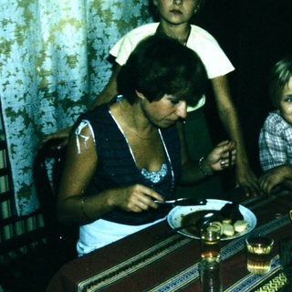Family sitting indoors at a table with food.