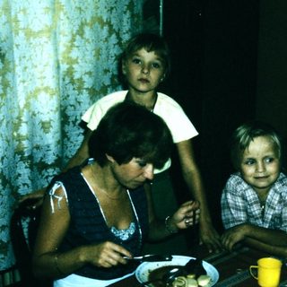 Family sitting indoors at a table with food.