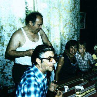 Family gathering playing piano indoors.