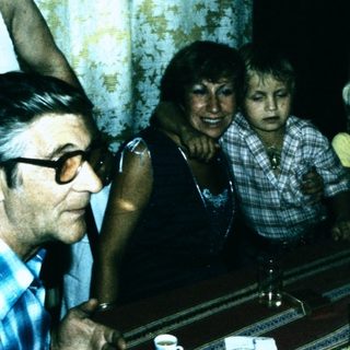 Family gathering playing piano indoors.