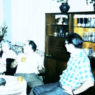 Group gathering in a living room playing card game.