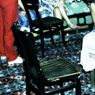 Group gathering in a living room playing card game.
