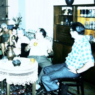 Group gathering in a living room playing card game.