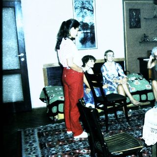 Group gathering in a living room playing card game.