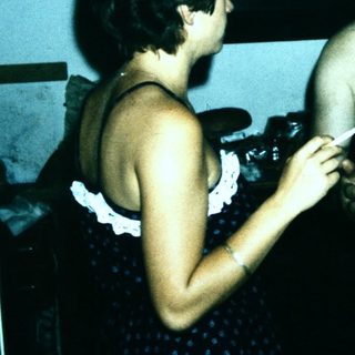 Shirtless man and woman in vintage indoor setting.